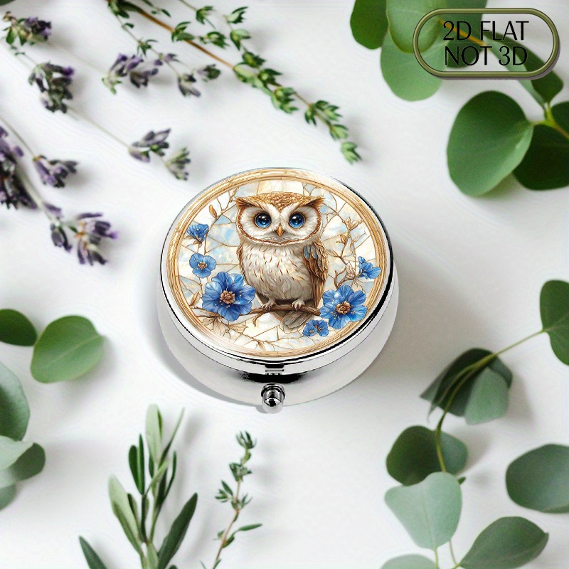 Travel Accessories As Gifts - 平らで持ち運び可能な丸い金属製のピルケースは、かわいいフクロウの模様と、花に囲まれたキラキラした目が特徴で、毎日の薬やビタミン剤、小さなアクセサリーの整理に最適です。旅行用として、また夏の祝祭日に大切な人への贈り物としても理想的です。